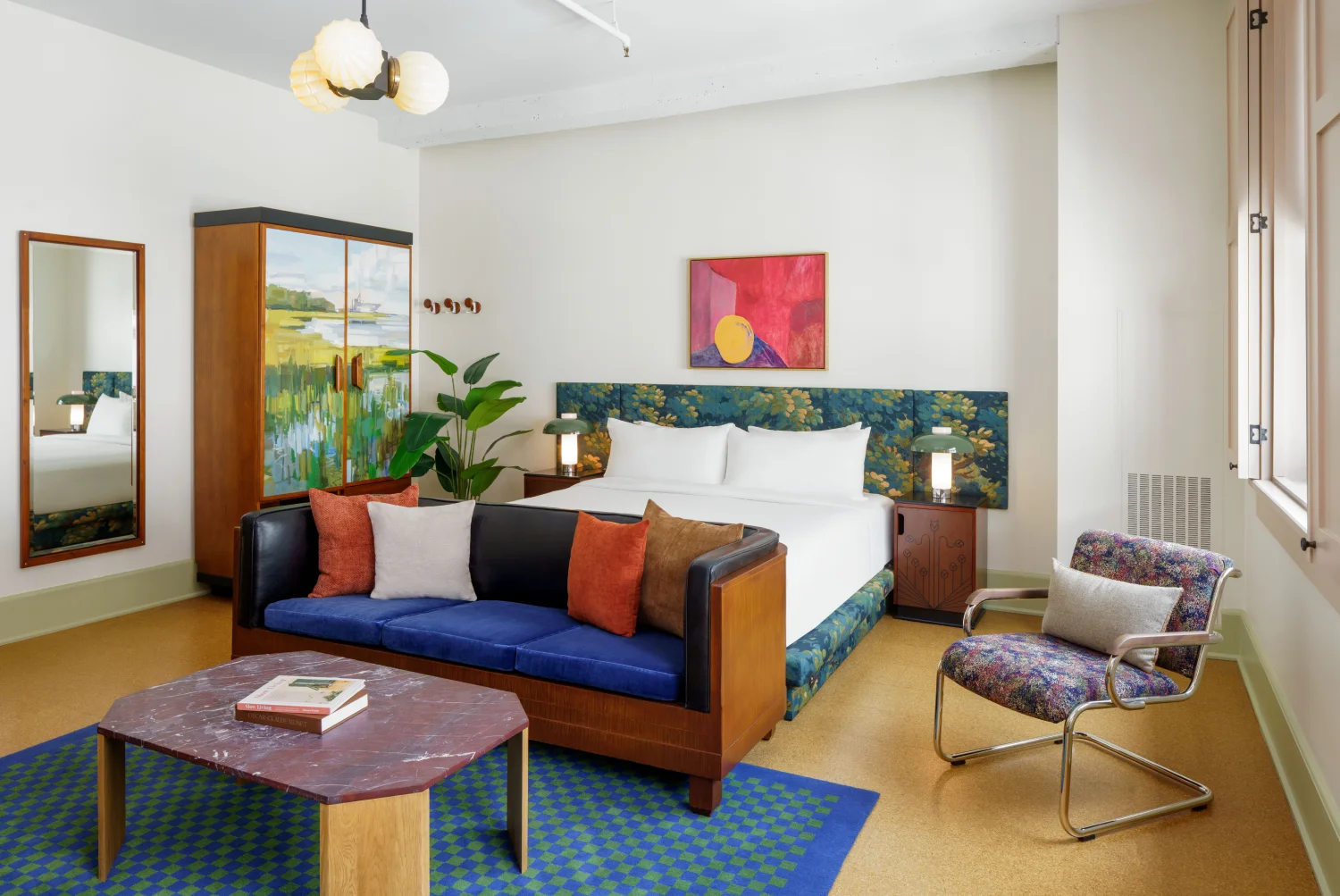 Detailed view of a vintage-modern hotel suite featuring dark furniture and large industrial windows