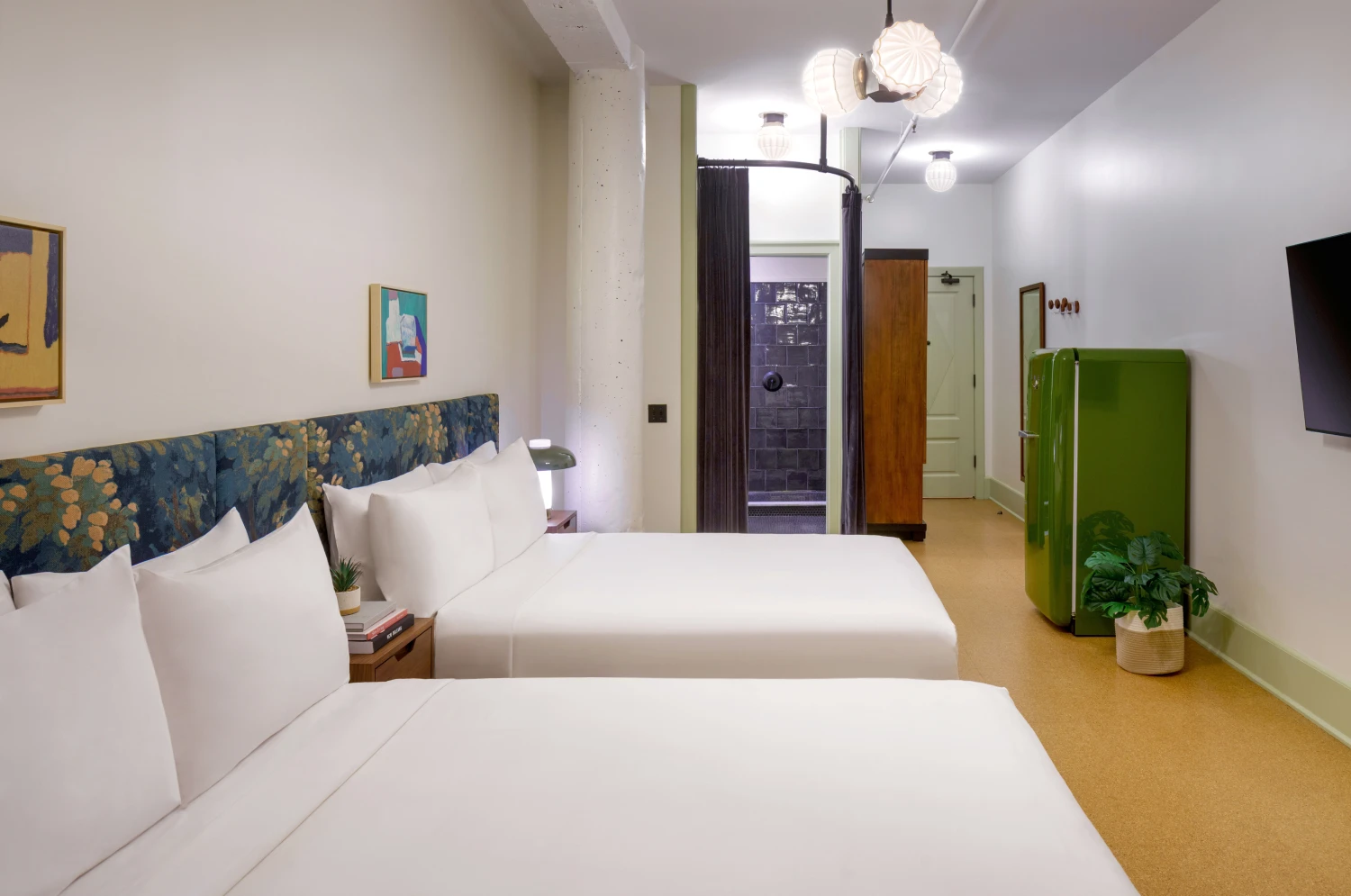 Professional shot of a stylish hotel room featuring two beds and a unique artistic wardrobe