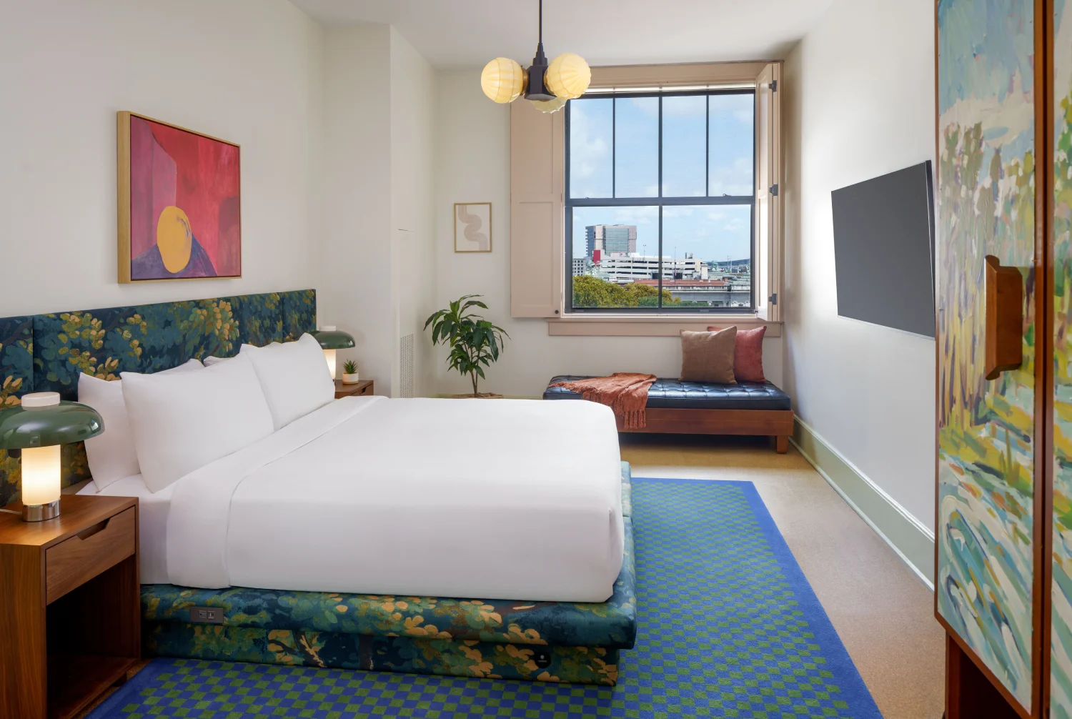 Professional shot of a king bed with white sheets and stylized nightstands typical of boutique hotels new orleans