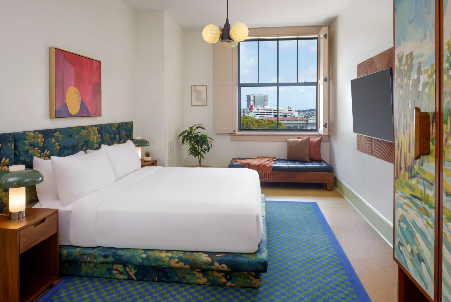 Professional shot of a king bed with white sheets and stylized nightstands typical of boutique hotels new orleans