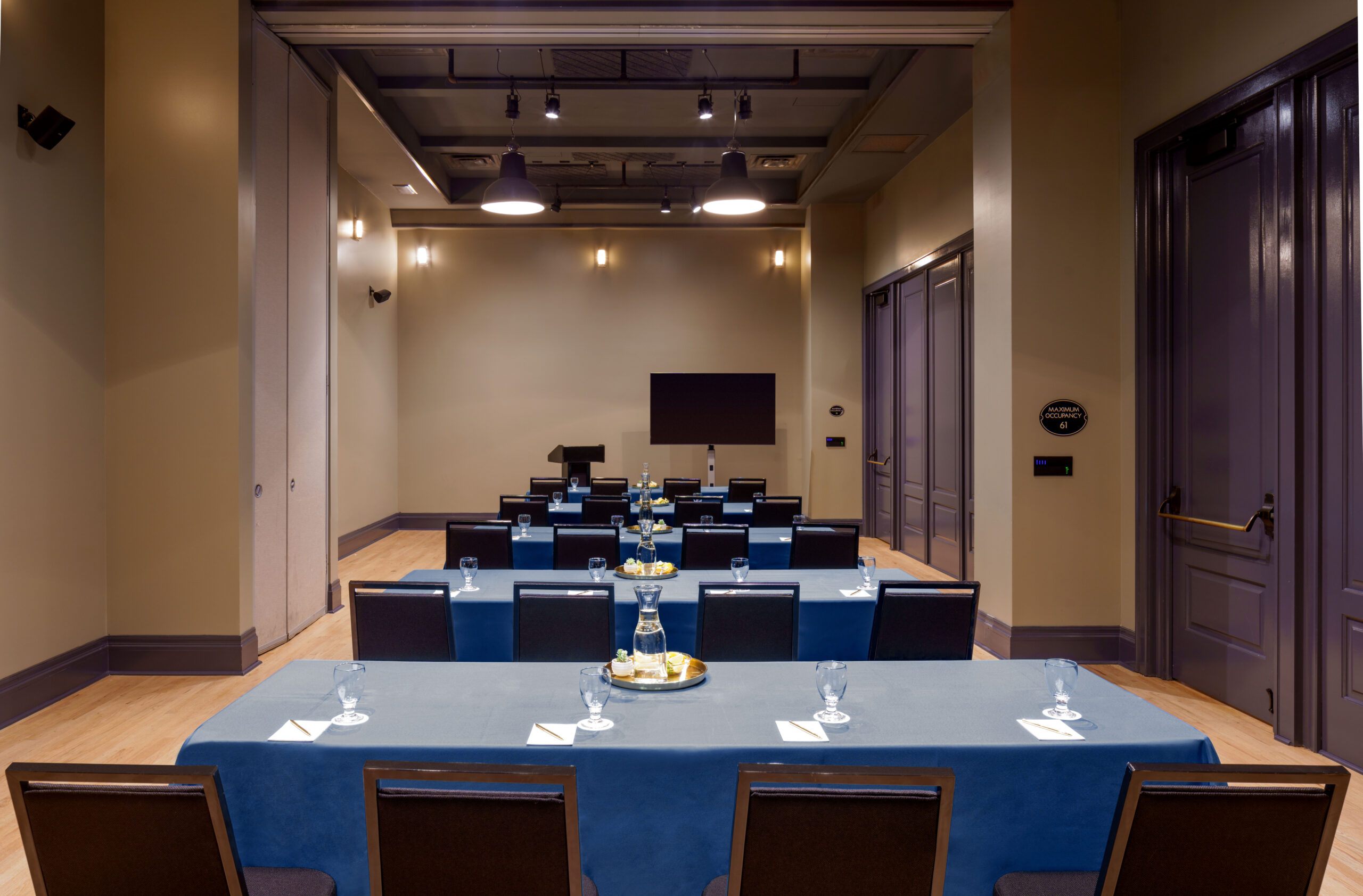 Brightly lit hotel conference room arranged in classroom style with blue linens for a business event