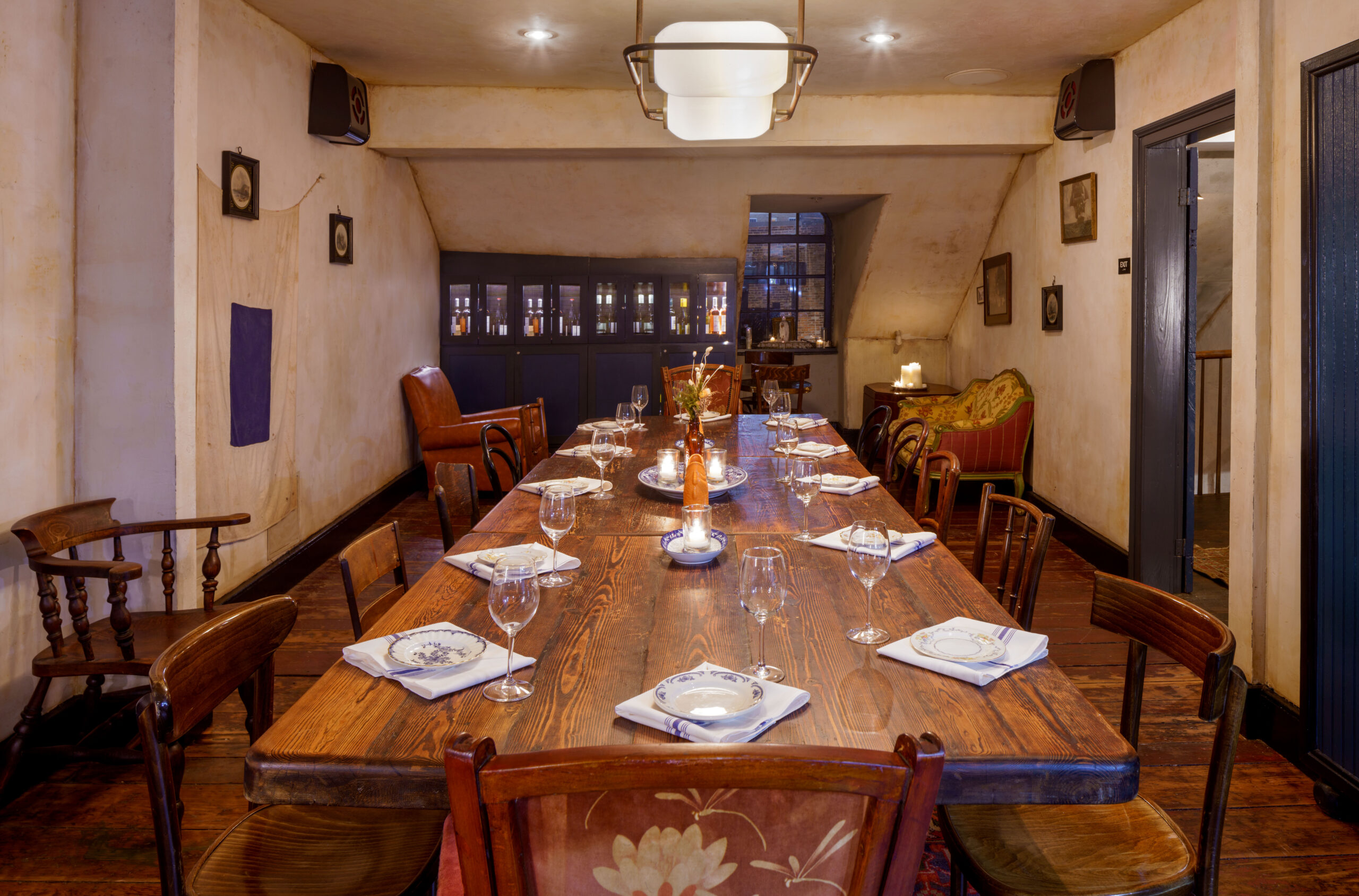 Intimate view of the private dining room with long wooden table and wine cabinet