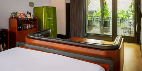 Modern suite design at boutique hotels New Orleans featuring a green fridge and private patio