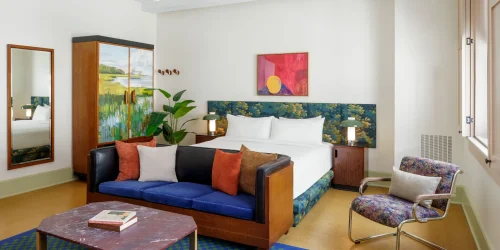 Detailed view of a vintage-modern hotel suite featuring dark furniture and large industrial windows