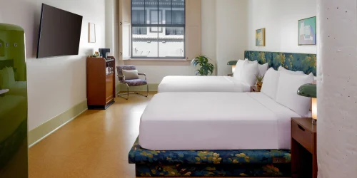 Professional shot of a stylish hotel room featuring two beds and a unique artistic wardrobe