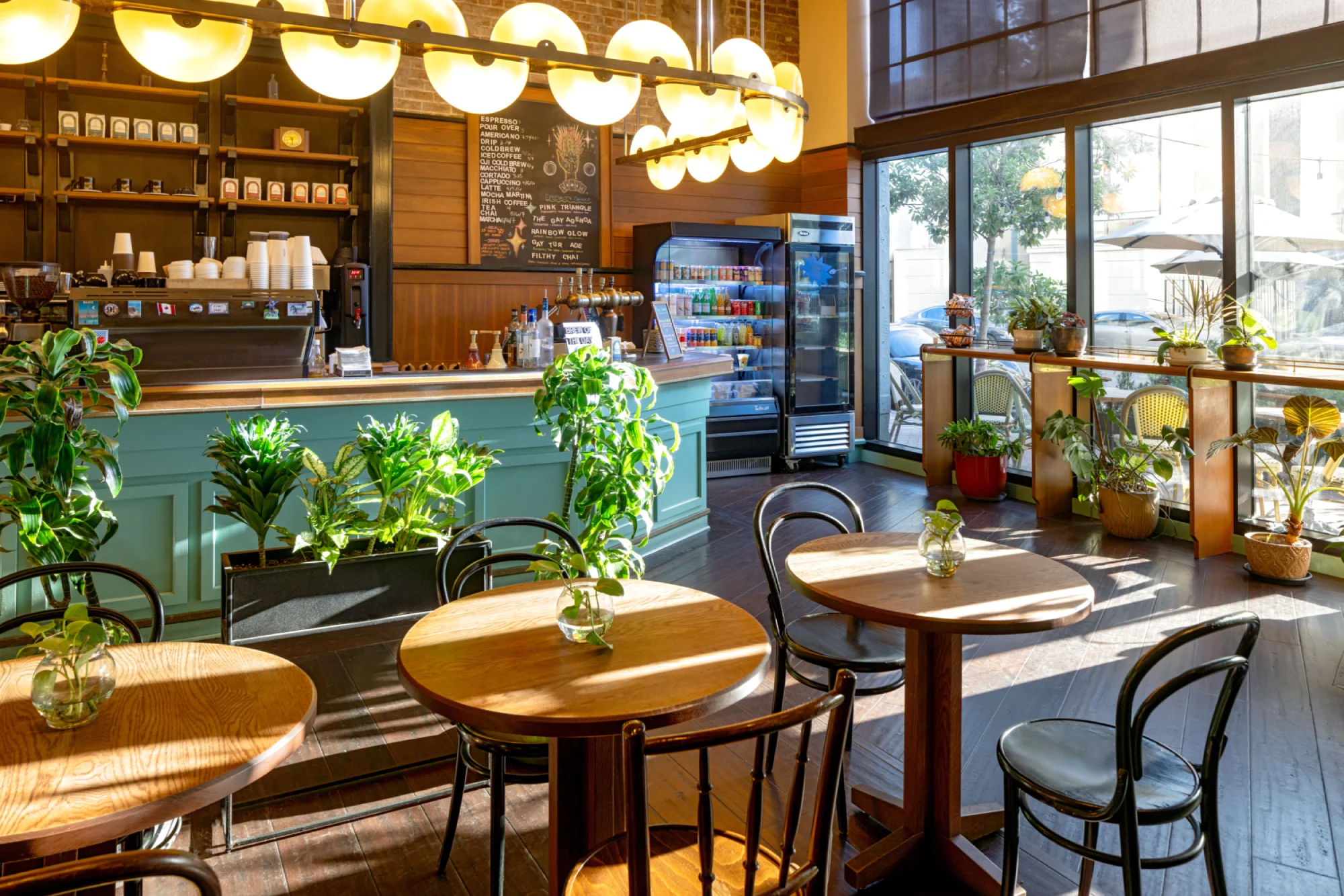 a restaurant with tables, chairs, and plants