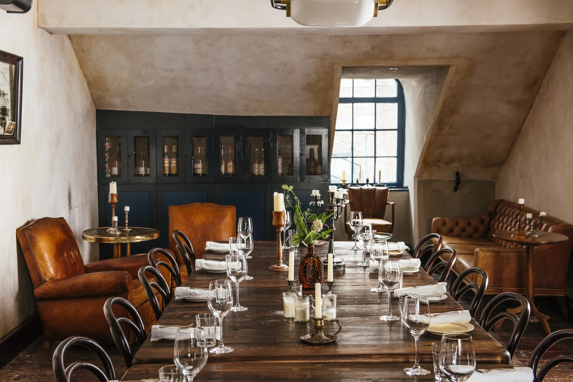 a long table is set with wine glasses and place settings