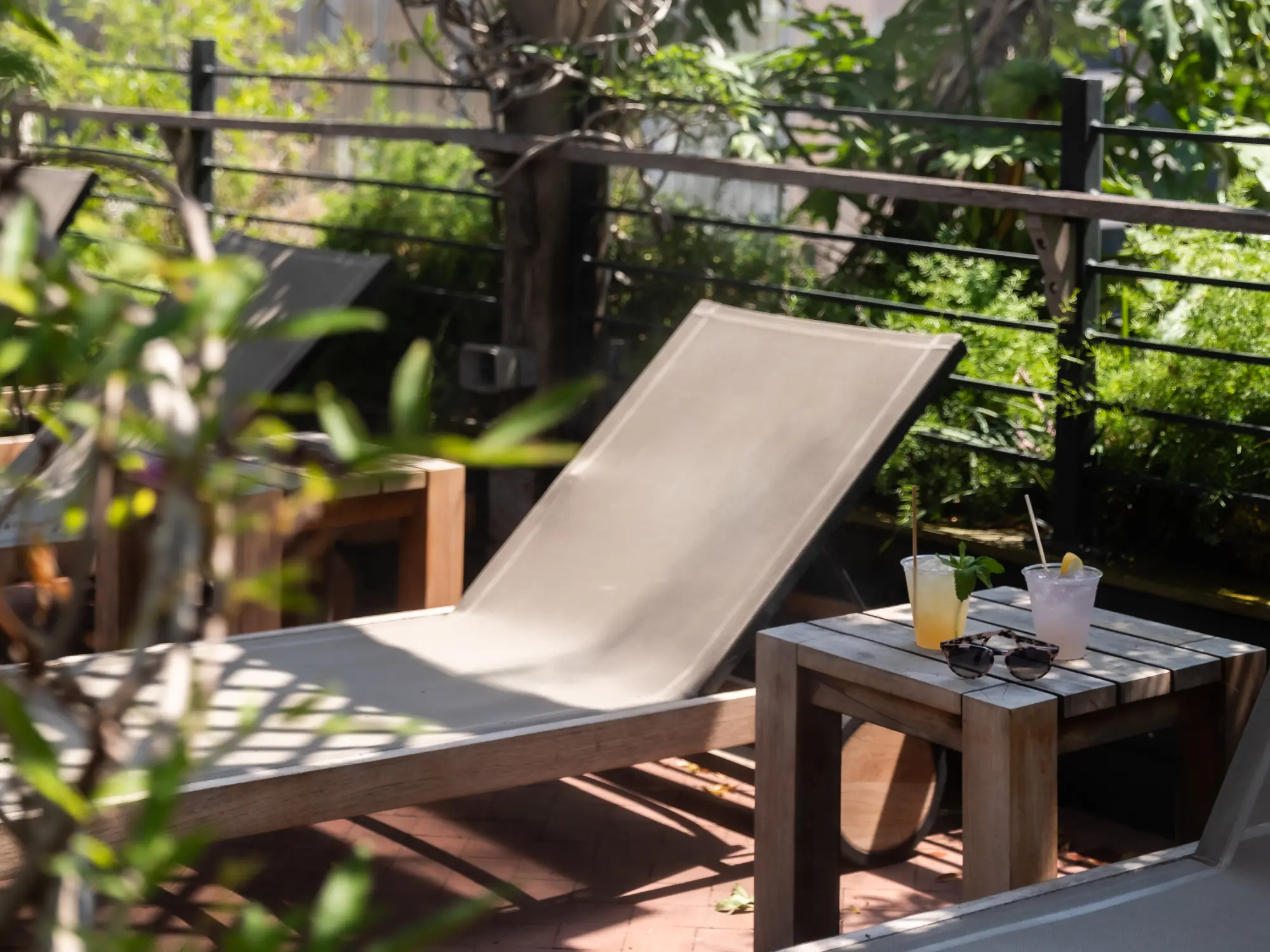 a table with a drink on it next to a lounge chair