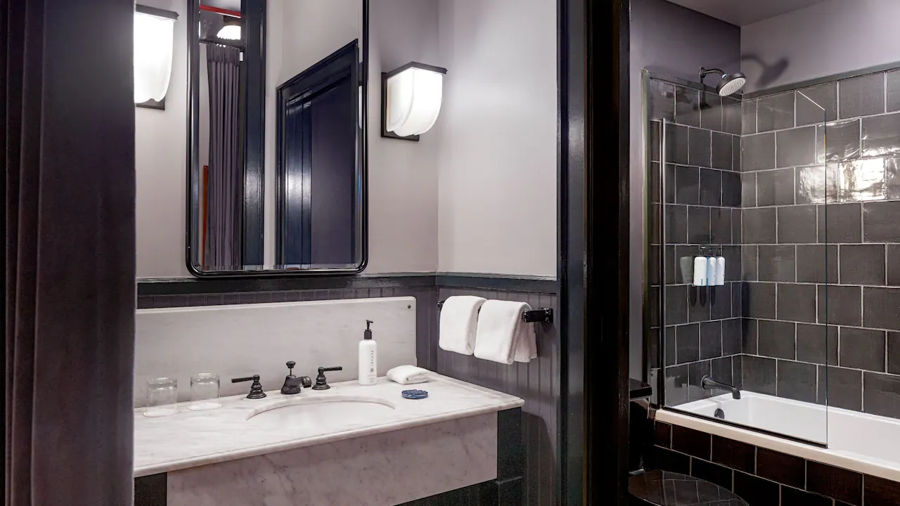 a bathroom with a sink, bathtub, and mirror