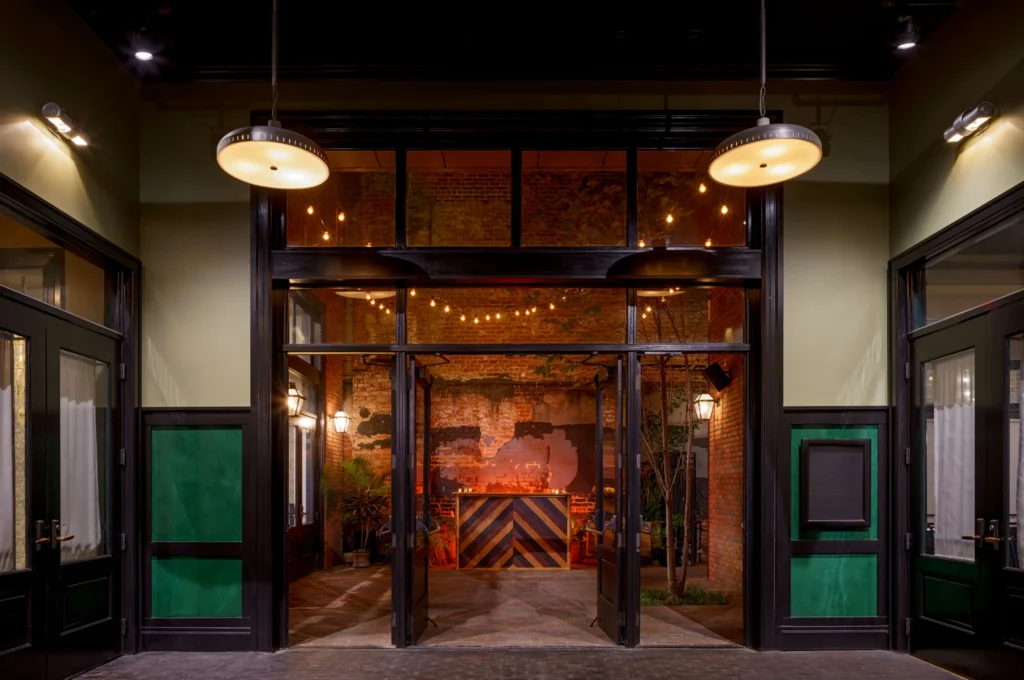 the entrance to a restaurant at night with lights on