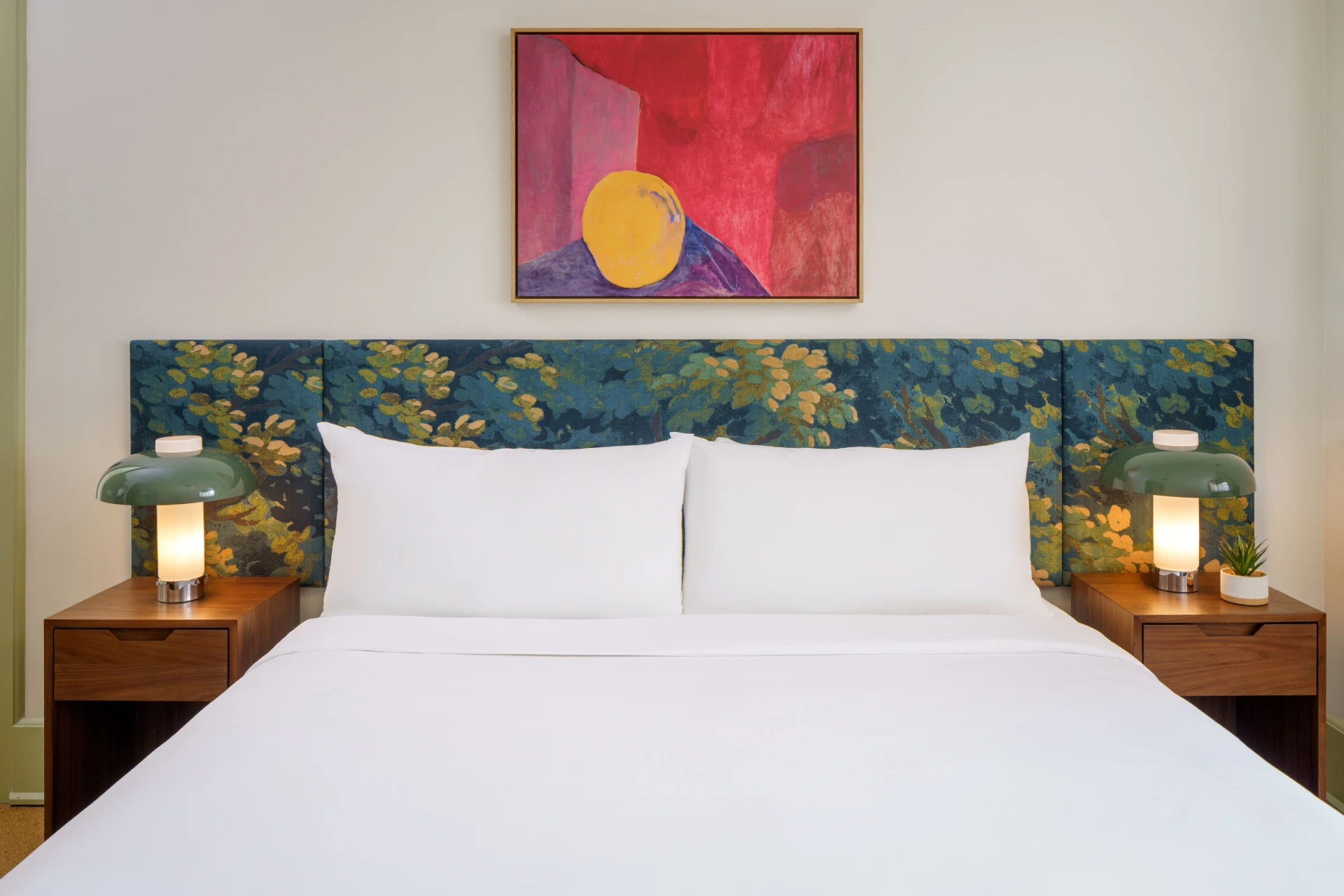 Detailed close-up of a modern boutique hotel room showing a nightstand and glowing green lamp